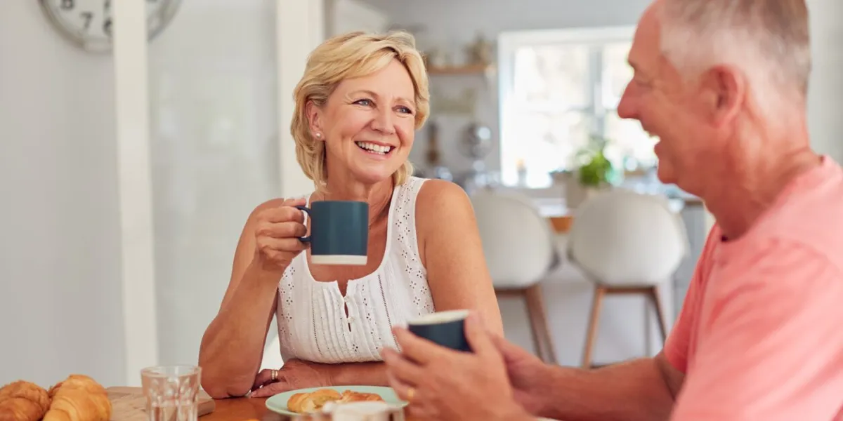 retired couple at home in kitchen eating breakfast together
