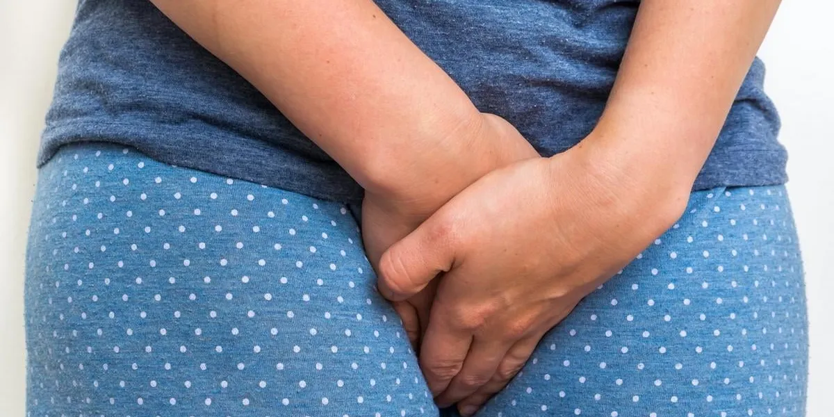 woman with incontinence problem is holding her crotch - incontinence concept