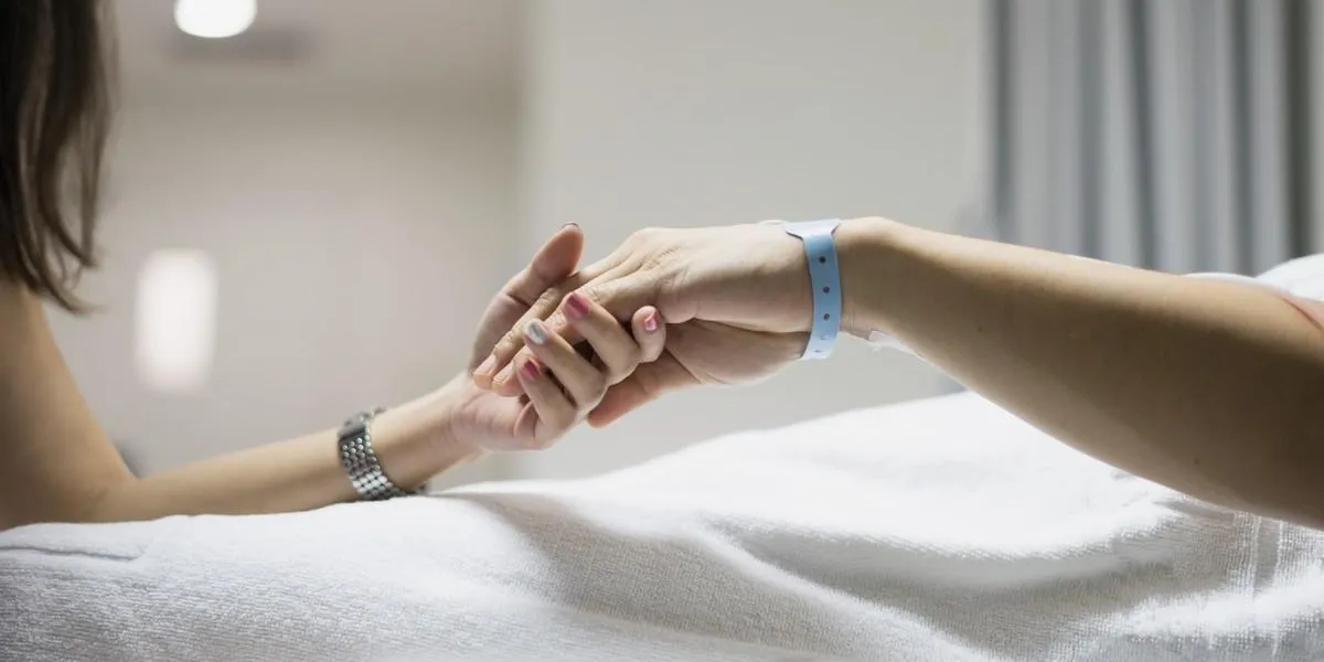 main de l'homme et la femme couple dans l'hôpital et le patient lit avec l'hôpital étiquette sur le poignet avec l'amour l'espoir et le soin