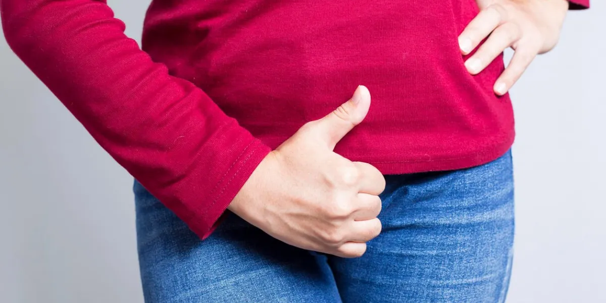 femme avec les mains tenant son entrejambe isolé sur fond blanc