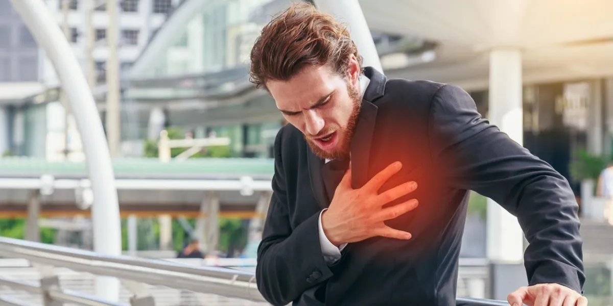 business man having heart attack or heart failure at outside in modern city, exhausted, tired, illness or overwork concept