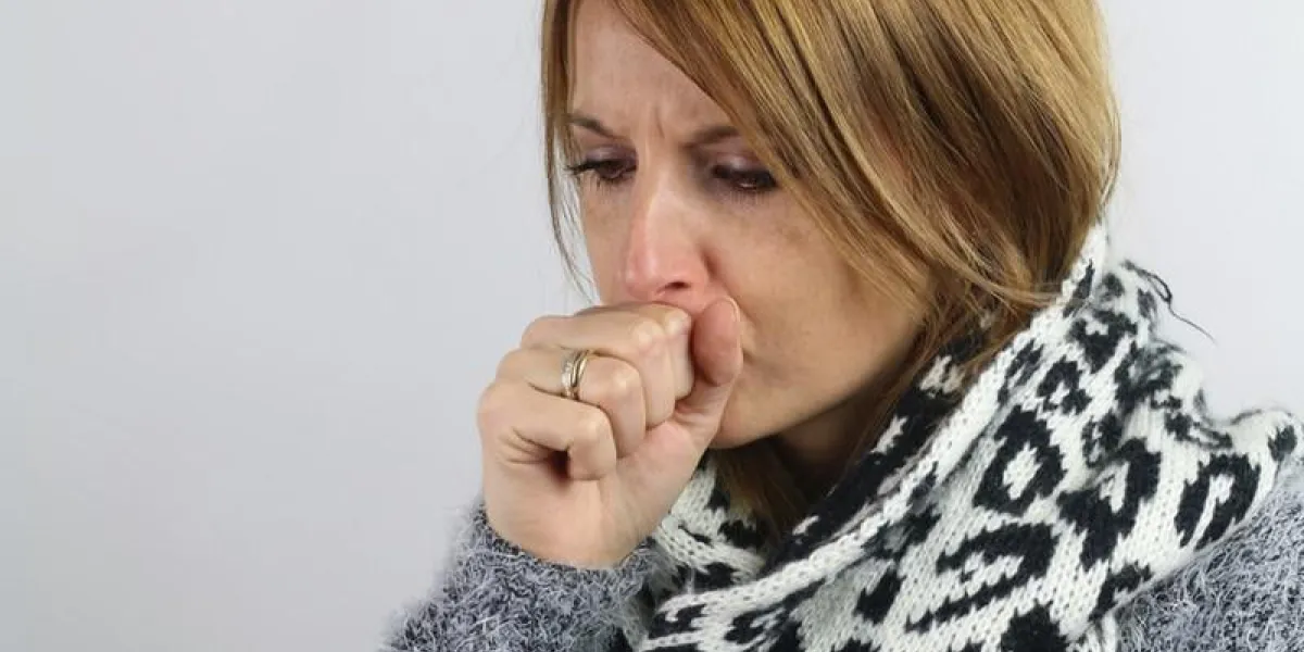 jeune femme tousse sur un fond blanc