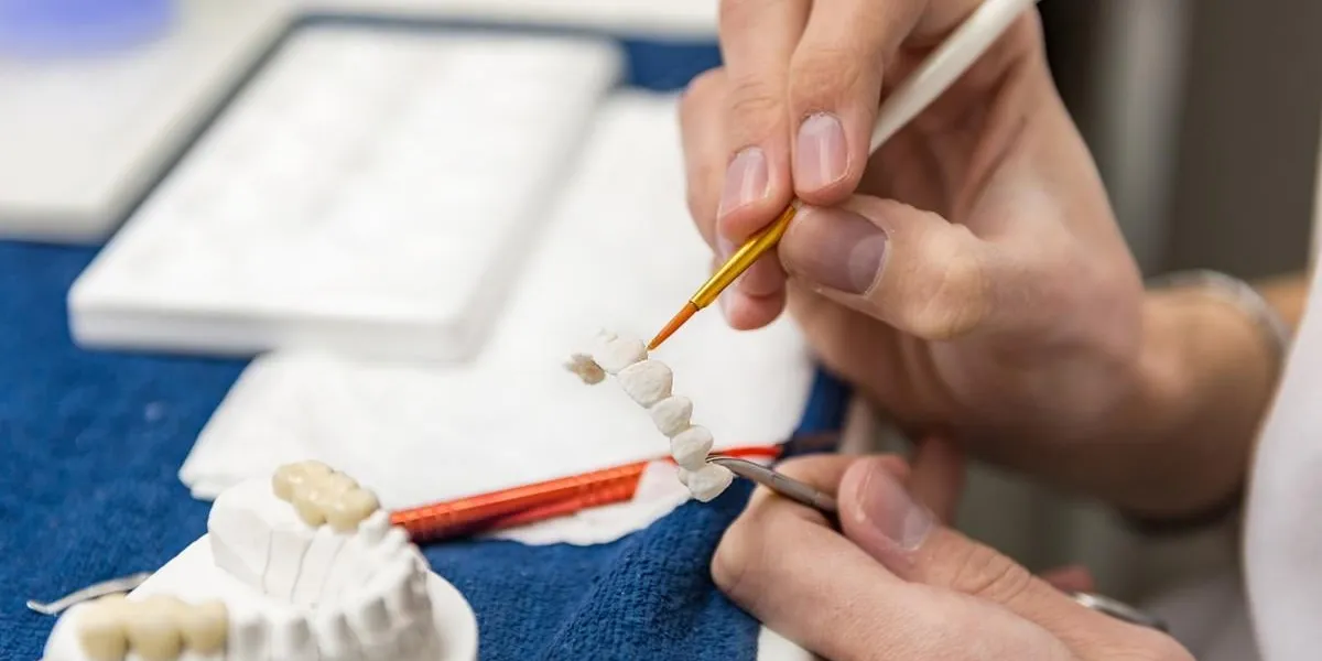 dental technician or dentist working with tooth dentures in his laboratory