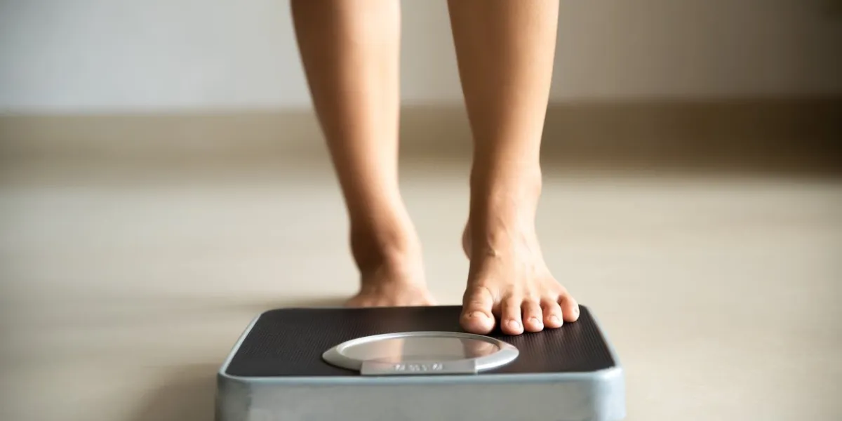 female leg stepping on weigh scales healthy lifestyle, food and sport concept