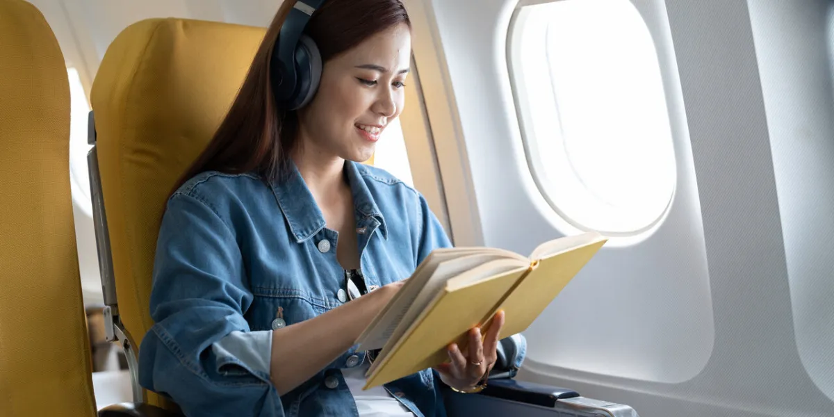 beautiful asian travel woman reading a book in airplane