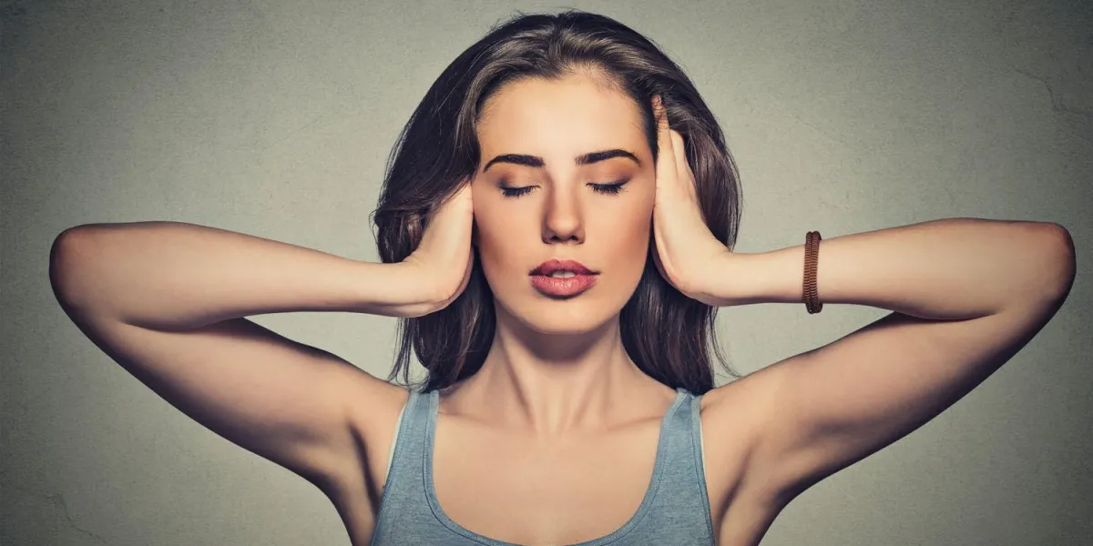portrait de jeune femme casual attrayant couvrant avec les mains ses oreilles yeux fermés isolé sur fond de mur gris n'entendre aucun concept mal
