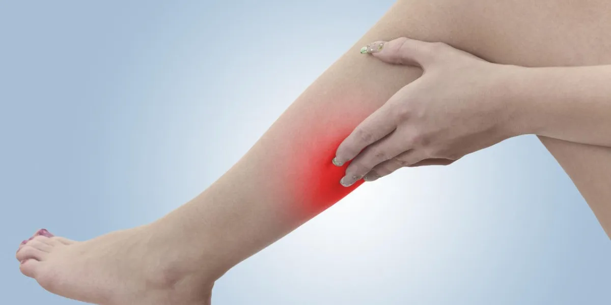 douleur dans une femme veau femelle tenant la main à la tache de veau-maux concept photo avec couleur peau bleue améliorée avec tache de lecture indiquant l'emplacement de l'isolement de la douleur sur un fond blanc