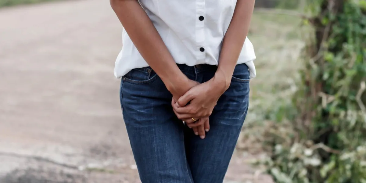 gros plan d'une femme avec les mains tenant son entrejambe