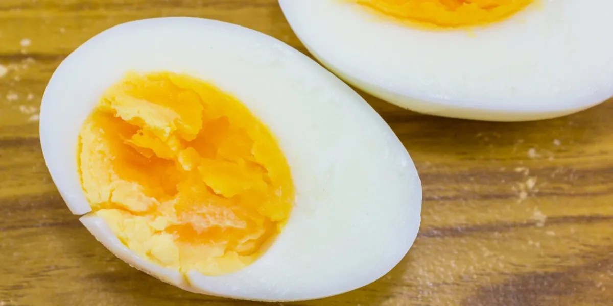 two halves of a boiled egg on wood background
