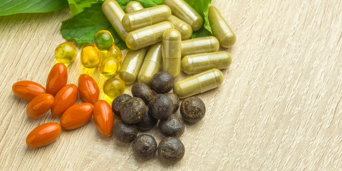 pilules à base de plantes avec des plantes médicinales vertes feuille verte, médicament alternatif sur bois