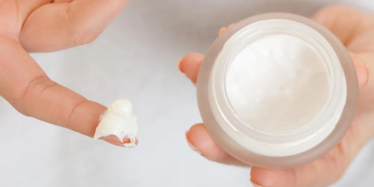 soins de la peau closeup de cosmétique jeune femme fille prenant soin de son teint sec en appliquant crème hydratante isolé traitement de beauté