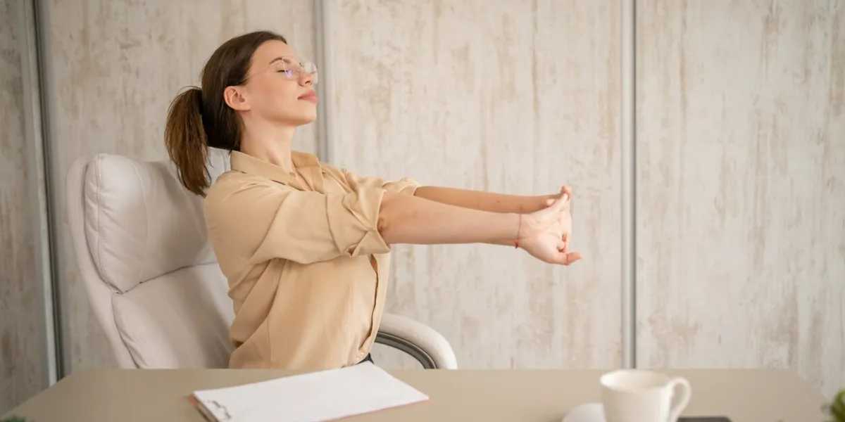 one woman female caucasian entrepreneur businesswoman or secretary sitting in office at desk at work stretching hands try to relax shoulders and back wear shirt copy space