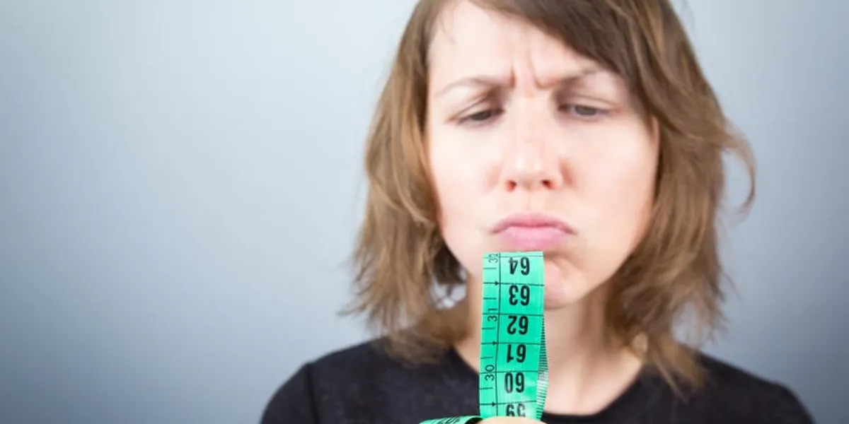 studio de belle jeune femme modèle tenant à la recherche de vert mesure mètre ruban régime concept de mode de vie sain