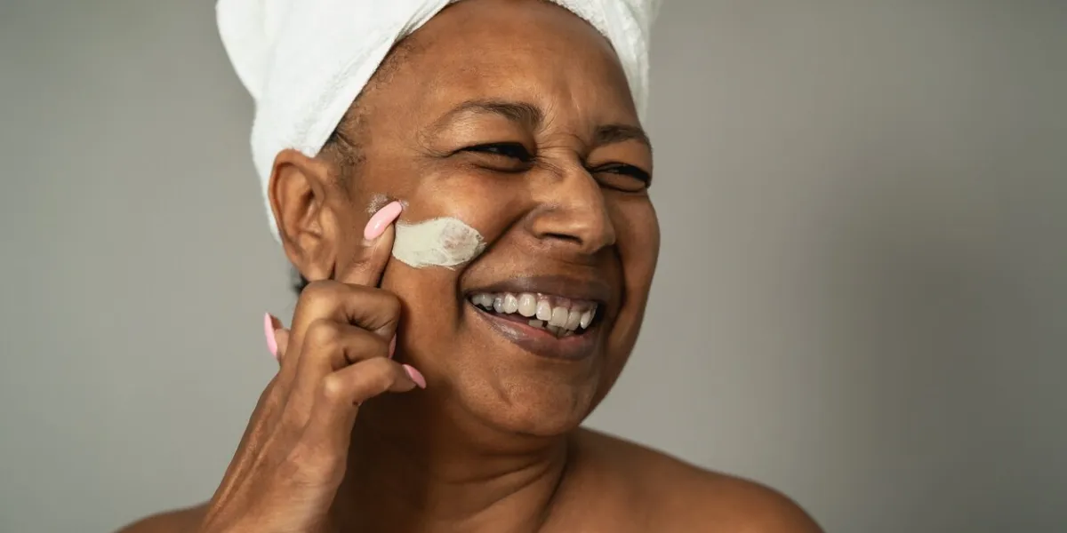 happy african senior woman having skin care spa day - people wellness lifestyle concept