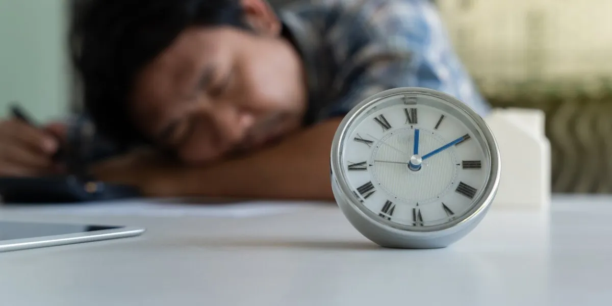 young business man laying on desk and taking a power nap after working finished blurred tired man sleeping at afternoon at he desk after working hard in an office