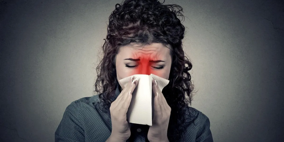 closeup portrait woman sneezing in a tissue blowing her runny nose