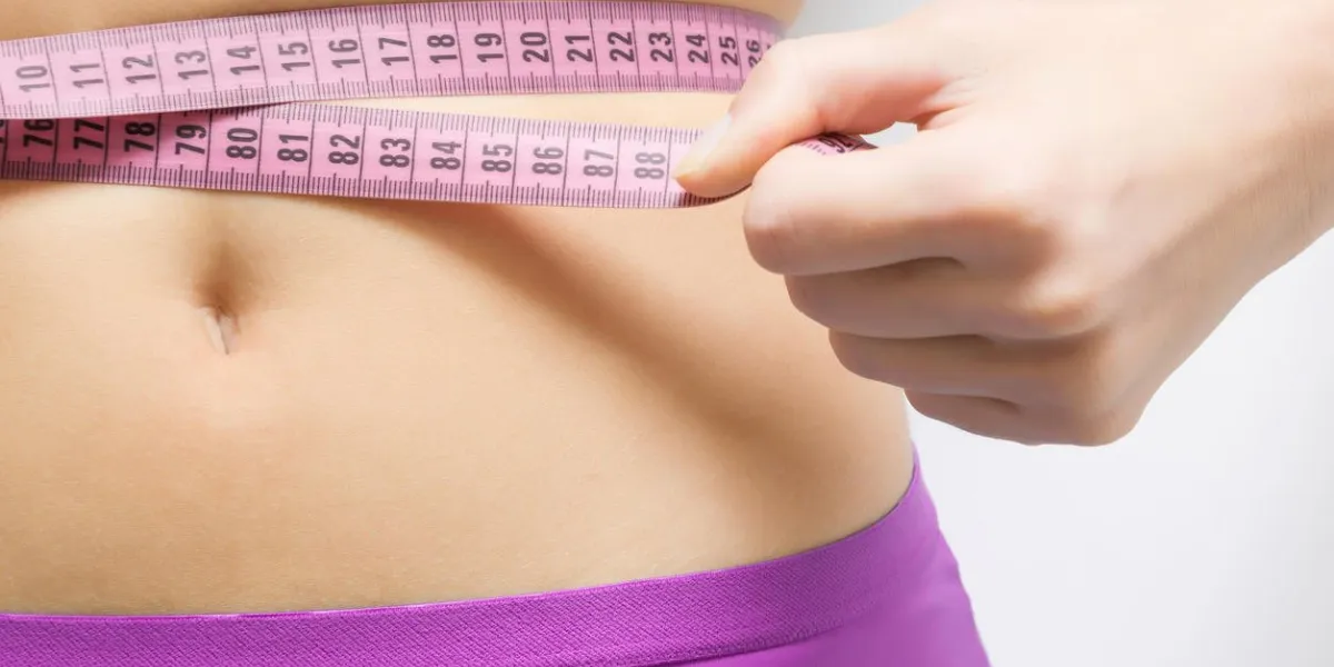woman measuring her waist cares about a body weight loss concept