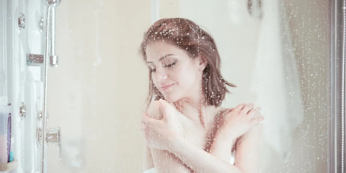 belle femme brune prendre une douche après une longue journée stressant douche et profiter de douche douche gel douche, lotion pour le corps, douche relaxant musclesépilation et traitement anti-cellulite