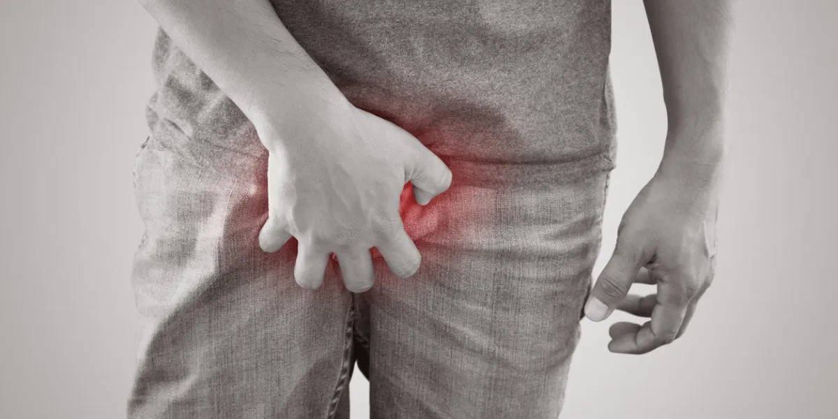 asian men are holding crotch against gray background people itching crotch human body problem or healthcare and medicine concept