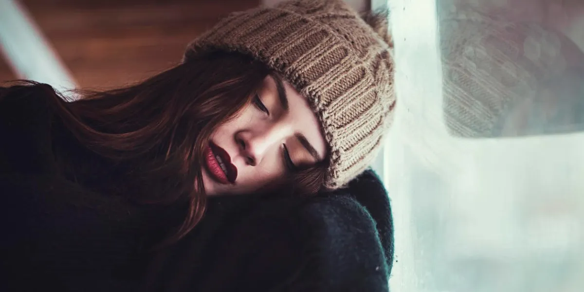 young woman sleeping infront of window