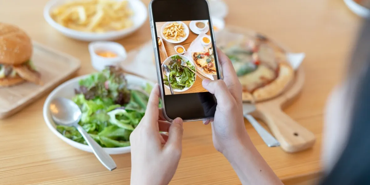 woman take picture of a meal on the table after ordering food online to eat at home photography and use phone concepts