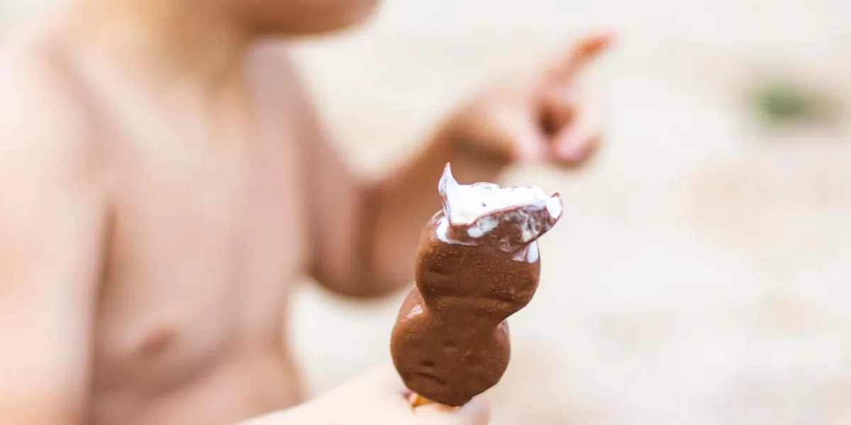 little kid eating an ice cream at beach