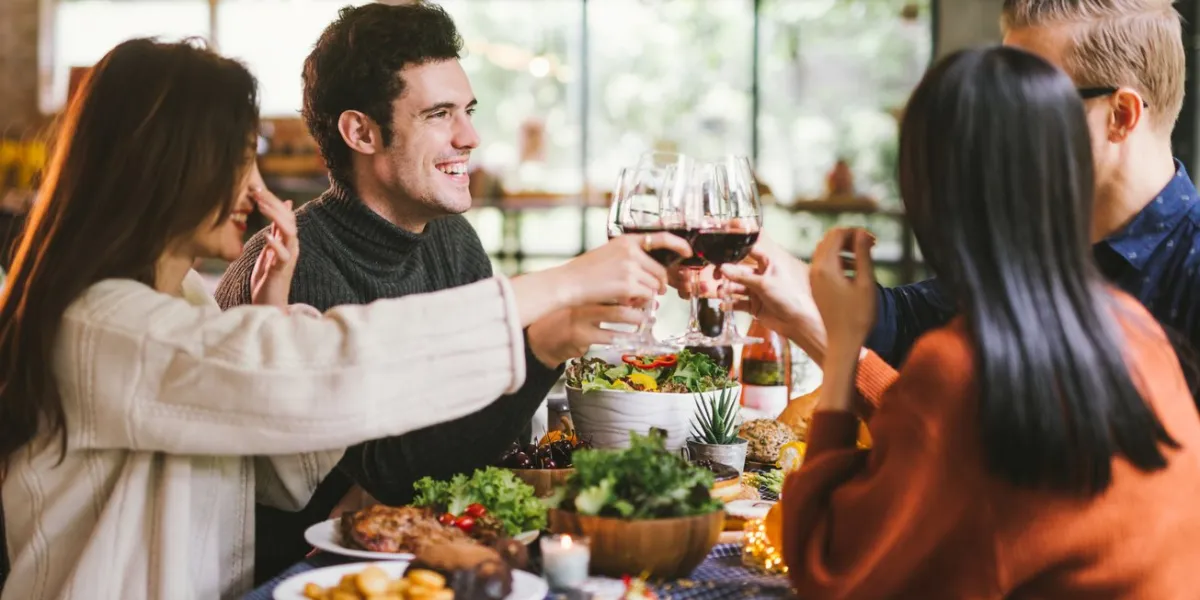 dinner with friends group of young people enjoying dinner together dining wine cheers party thanksgiving concept