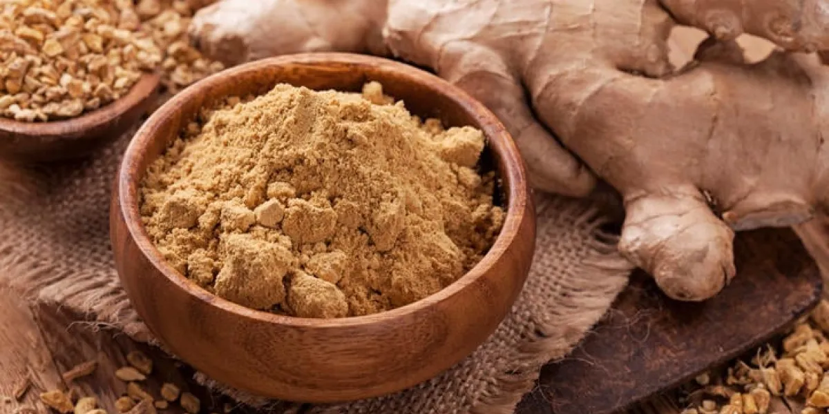 racine fraîche de gingembre et épices au gingembre sur une table en bois