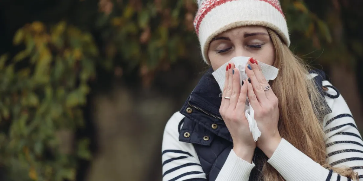woman suffering from cold outdoor with tissue
