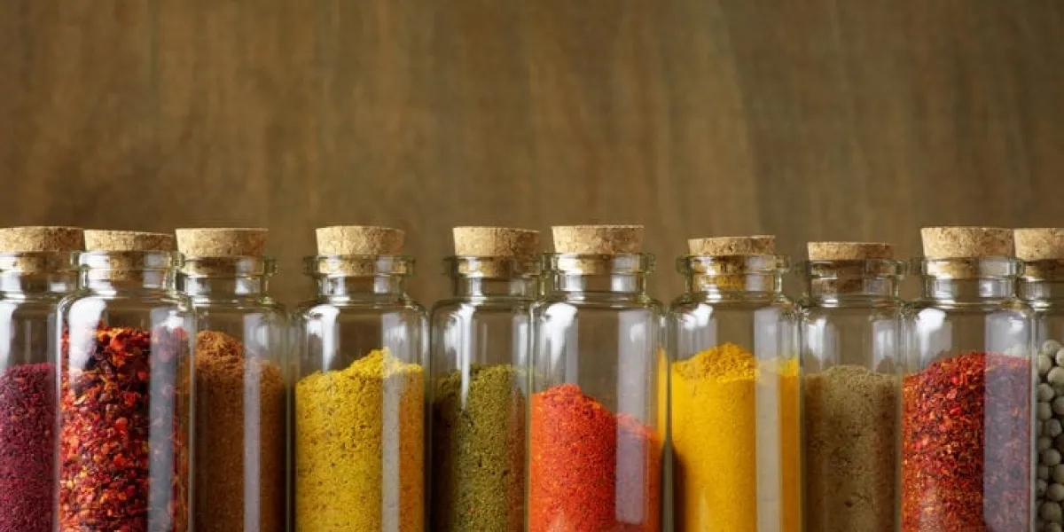 assorted ground spices in bottles on wooden background