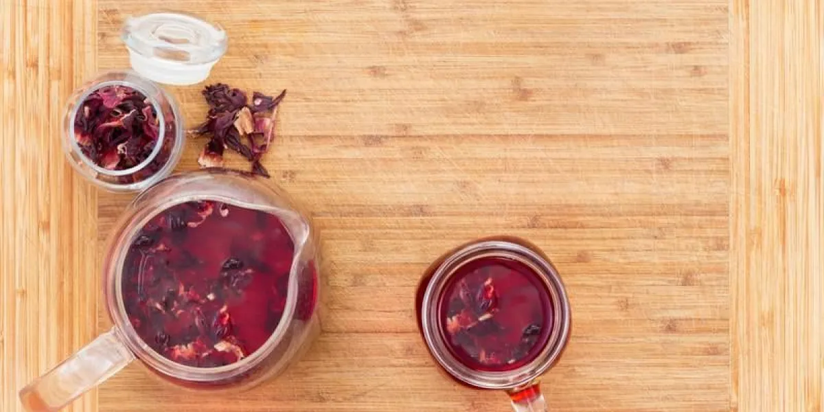 vue aérienne, de, chaud, hibiscus, thé, dans, verre, pichet, et, tasse, servi, sur, léger, bois, table bois