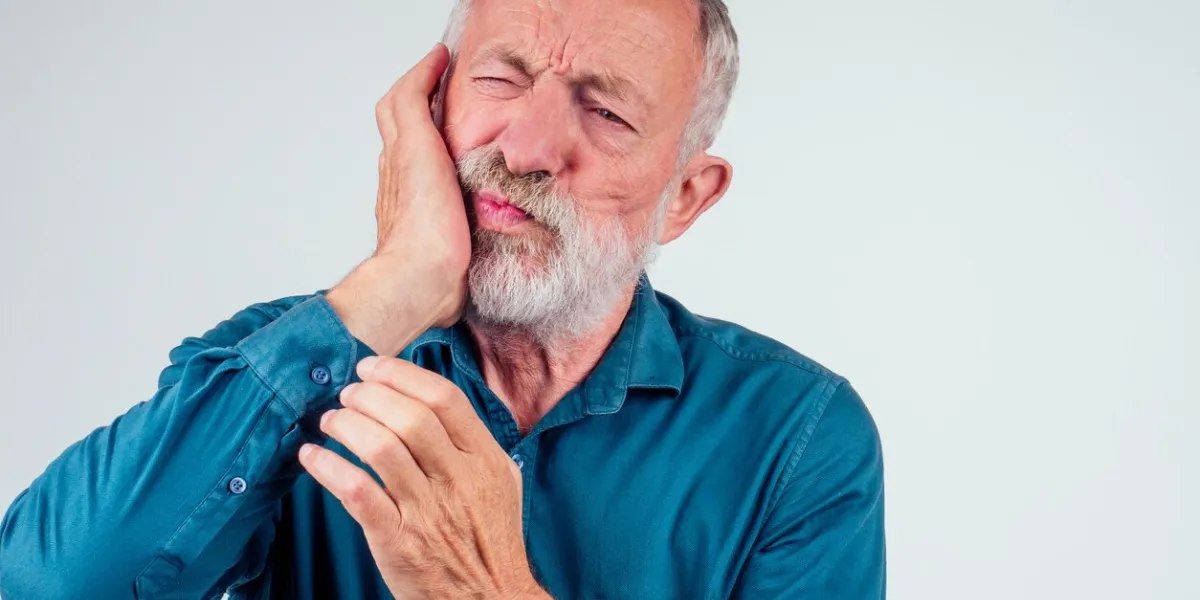 unhappy senior man with closed eyes holding cheek isolated white background, strong pain in tooth decay