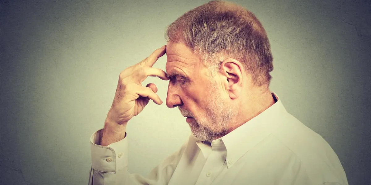 closeup portrait d'un homme réfléchi senior isolé sur fond de mur gris