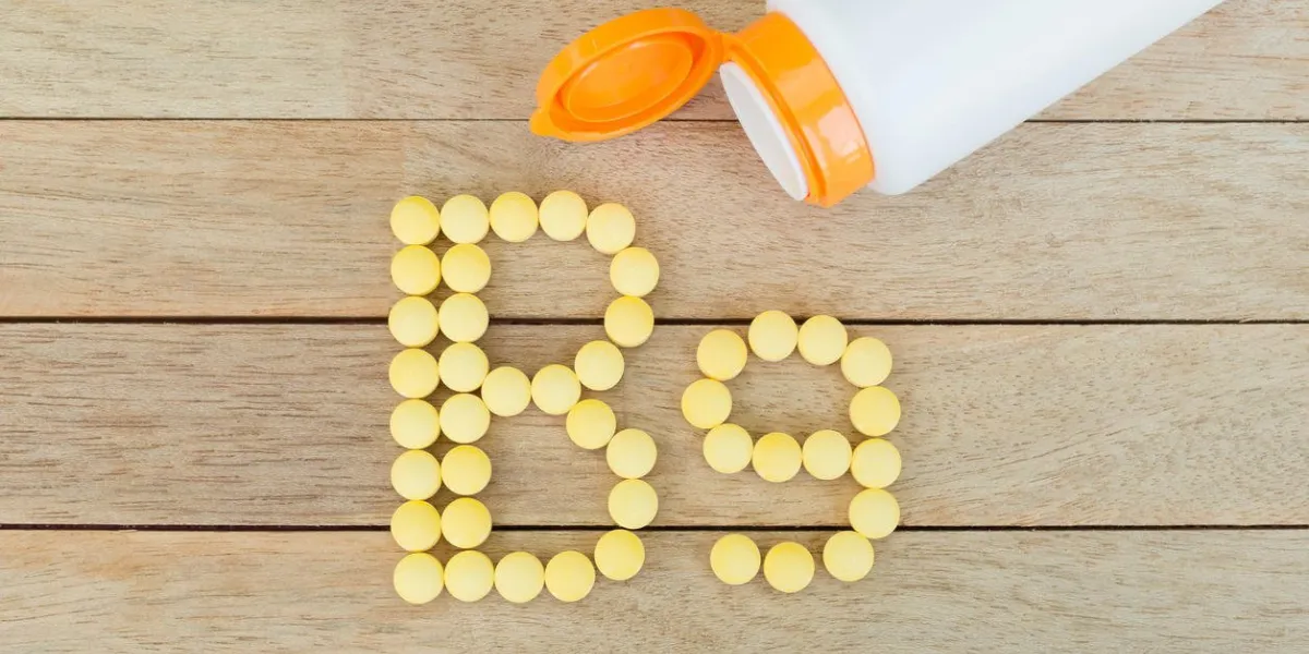 pilules jaunes formant la forme de l'alphabet b9 sur fond de bois