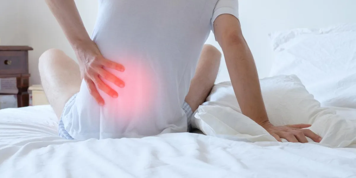 man waking up in the morning and suffering because of backache