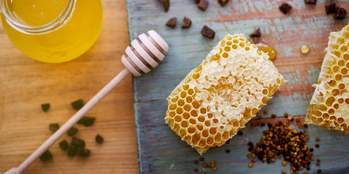 honey background sweet honey in a glass jar, honeycombs, propolis and pollen on the table