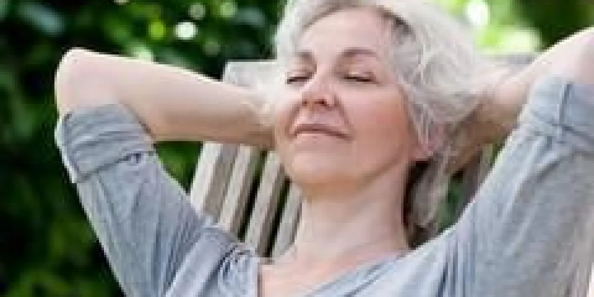 femme aux cheveux gris se détendre sur la terrasse ensoleillée