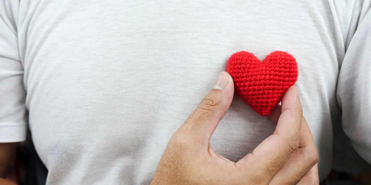 man with red heart on left chest