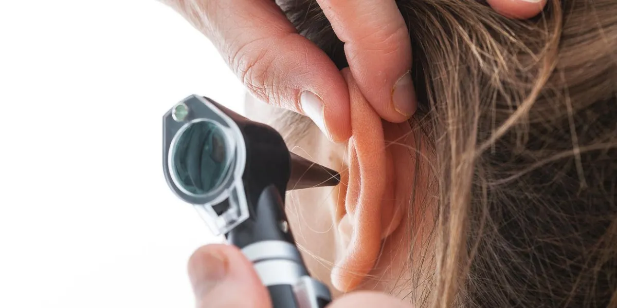 gros plan d'examiner l'oreille avec un otoscope