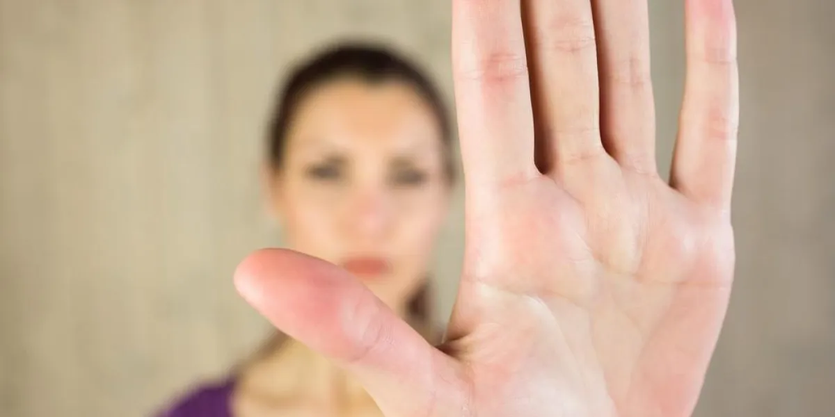 femme montrant le panneau d'arrêt