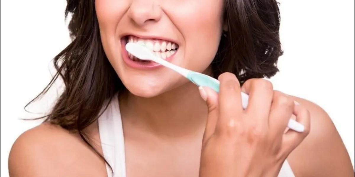 souriante jeune femme avec des dents saines tenant une brosse à dents