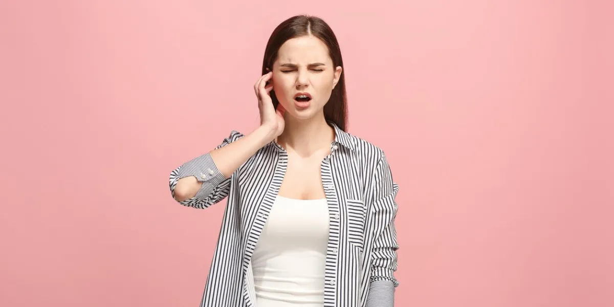 sore ear ear ache concept the sad crying woman with headache or pain on trendy pink studio background facial expressions and people emotions concept front view half-length portrait young woman