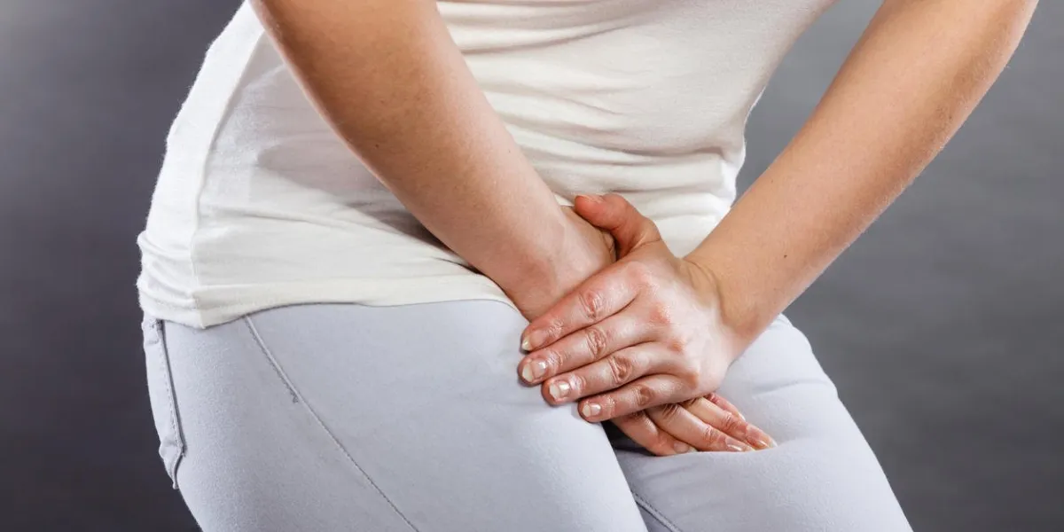 jeune femme malade avec les mains tenant pressant son entrejambe bas abdomen problèmes médicaux ou gynécologiques, concept de soins de santé