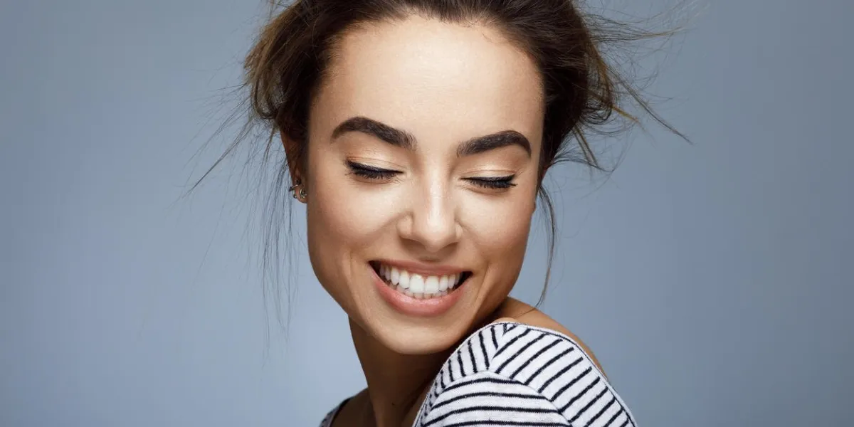 closeup portrait of young woman with toothy smile