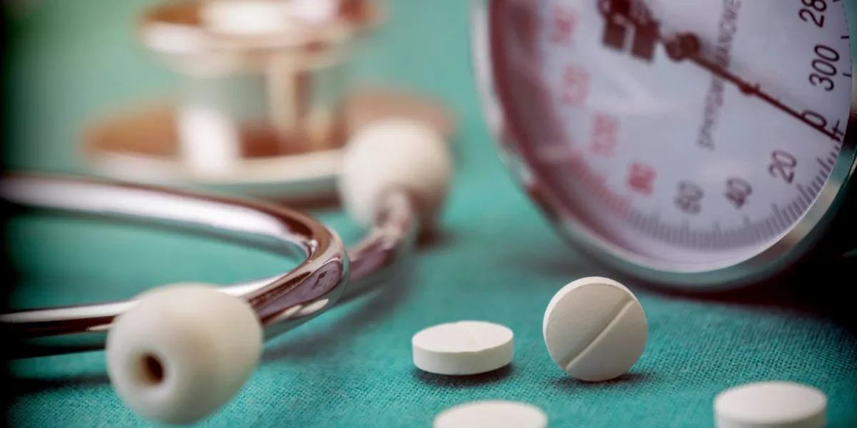 white pad next to a manometer to measure blood pressure and a stethoscope in a hospital, conceptual image