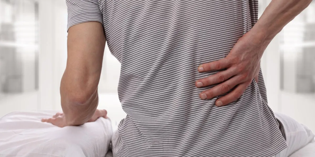 homme souffrant de maux de dos à la maison dans la chambre inconfortable matelas et oreiller provoque des maux de dos