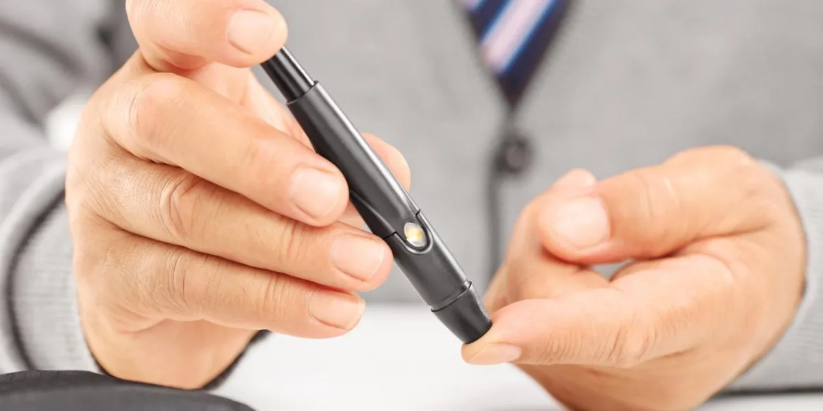 gros plan d'un patient diabétique mature mesurant le niveau de sucre dans le sang en utilisant glucomètre