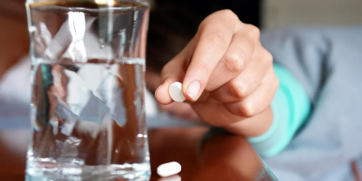 femme avec un comprimé de grippe