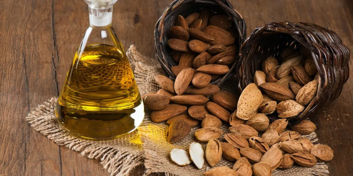 amandes, huile entière et d'amande sur une vieille table en bois rustique