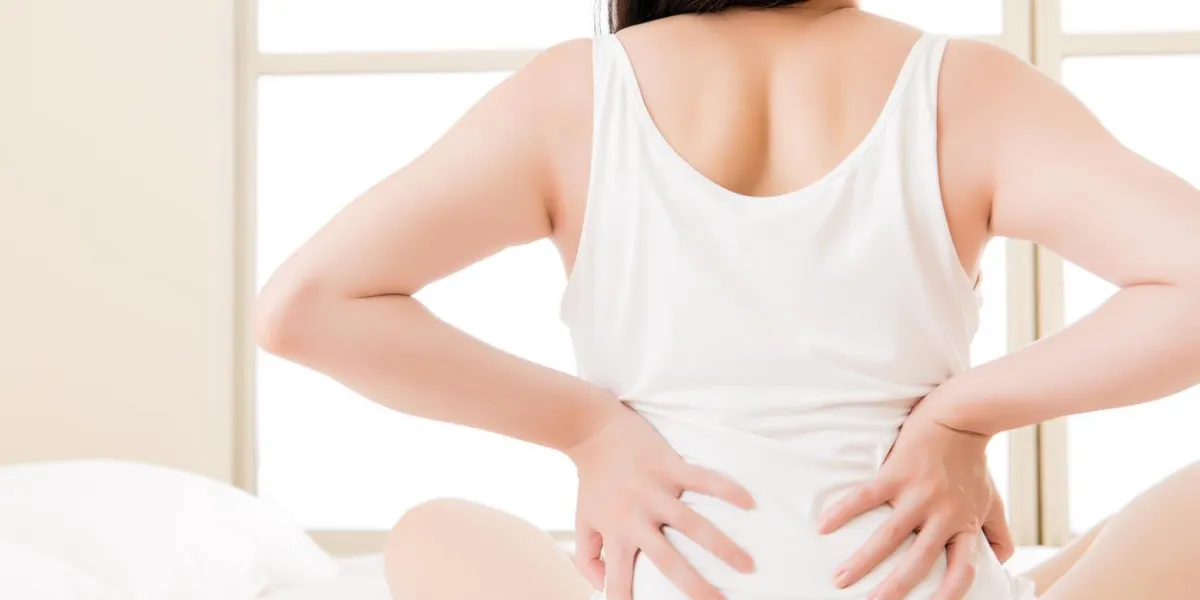 femme asiatique souffre de maux de dos maux de dos, la colonne vertébrale ou le bas du dos problème de fond de chambre à coucher